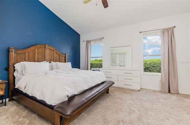 bedroom featuring ceiling fan, light carpet, baseboards, and lofted ceiling