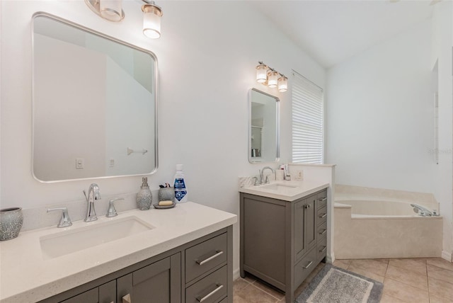 full bath with two vanities, a sink, tile patterned flooring, and a garden tub