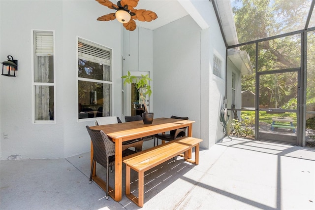 sunroom with outdoor dining area and ceiling fan