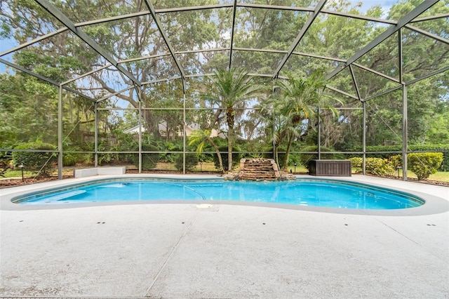 pool with glass enclosure and a patio area