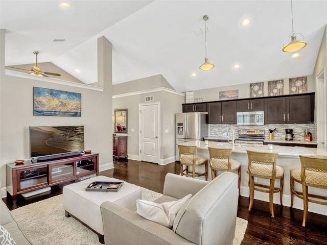 living area featuring a ceiling fan, baseboards, and dark wood finished floors