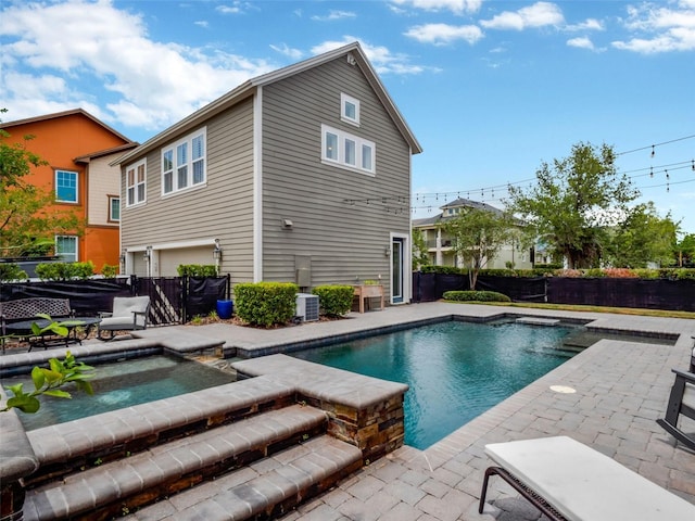 outdoor pool with a fenced backyard, central AC unit, an in ground hot tub, and a patio