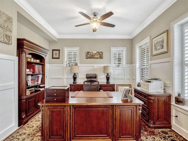 office featuring a decorative wall, ceiling fan, ornamental molding, and a wainscoted wall
