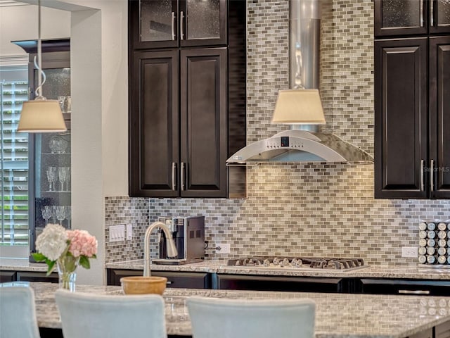 kitchen with stainless steel gas cooktop, dark brown cabinets, and tasteful backsplash