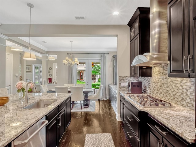 kitchen with visible vents, a sink, dark wood-style floors, stainless steel appliances, and wall chimney exhaust hood