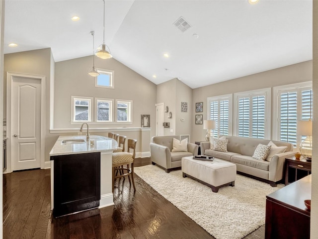 living room with baseboards, vaulted ceiling, dark wood-style flooring, and visible vents