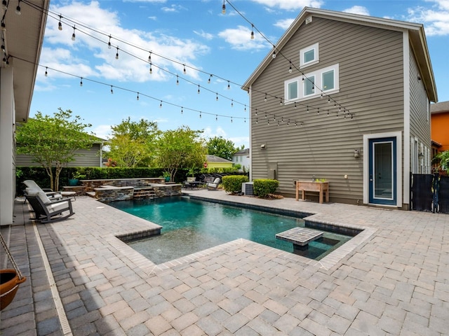view of swimming pool featuring a patio and a pool with connected hot tub