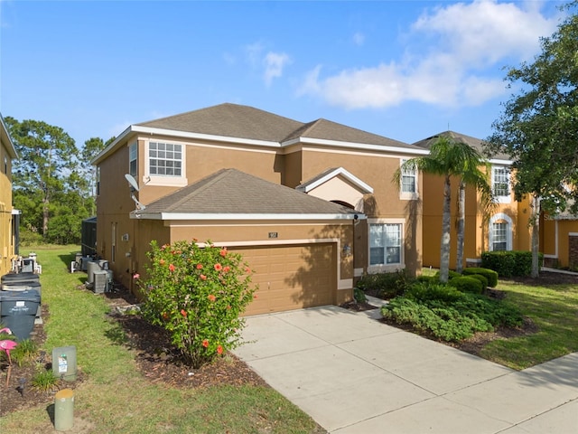 view of front of house with a front yard, a garage, stucco siding, and driveway