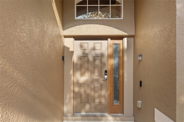 view of exterior entry featuring stucco siding
