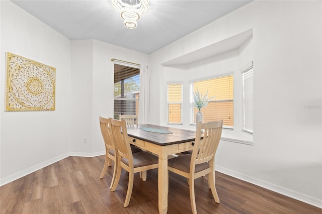 dining space with baseboards and wood finished floors