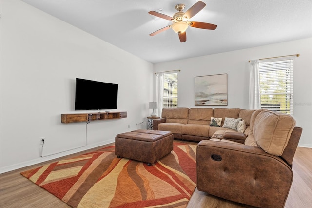 living room with baseboards, a ceiling fan, and wood finished floors