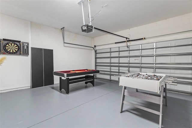 recreation room featuring concrete block wall, pool table, a garage, and concrete floors