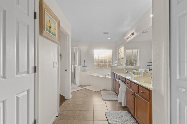 full bath with a stall shower, baseboards, a bath, tile patterned floors, and double vanity