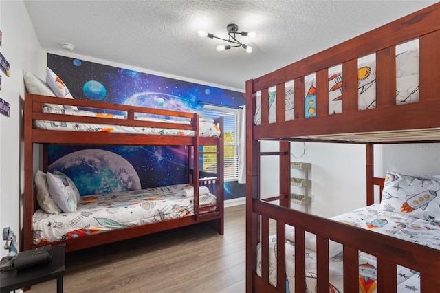 bedroom with a textured ceiling and wood finished floors