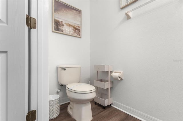 bathroom with toilet, wood finished floors, and baseboards