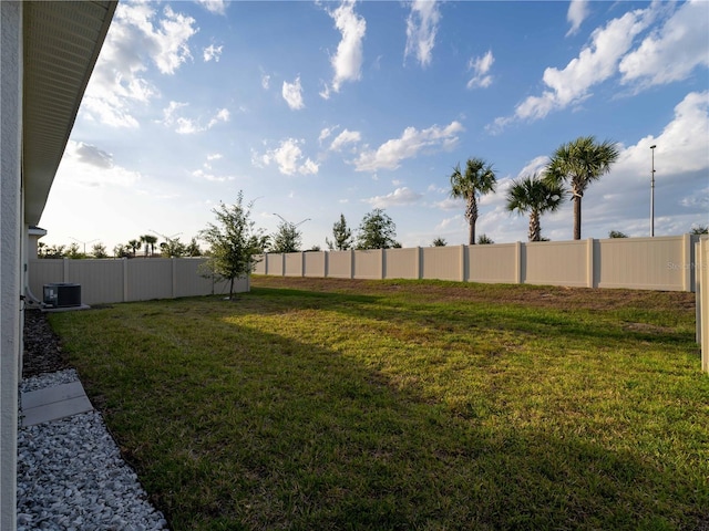 view of yard with fence and central AC