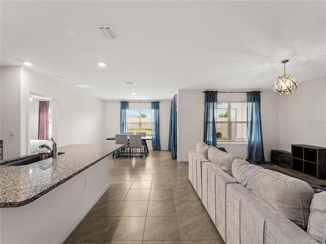 living room with baseboards, visible vents, plenty of natural light, and light tile patterned floors