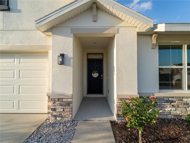 property entrance with stucco siding and stone siding