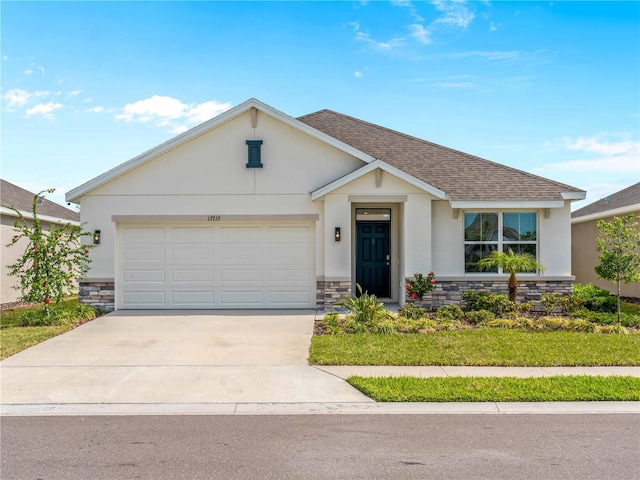 ranch-style home with an attached garage, stucco siding, concrete driveway, and stone siding