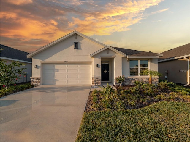 view of front of property featuring an attached garage, stucco siding, stone siding, and concrete driveway