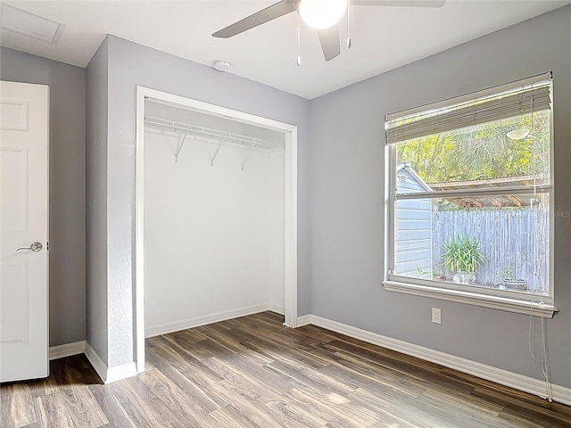unfurnished bedroom featuring ceiling fan, baseboards, wood finished floors, visible vents, and a closet