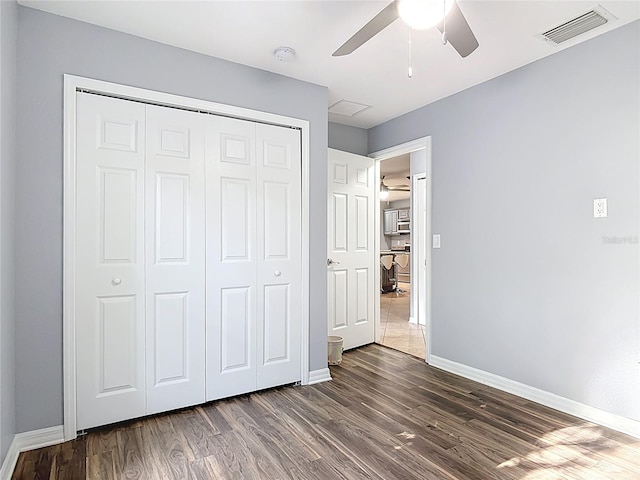 unfurnished bedroom featuring visible vents, baseboards, and wood finished floors