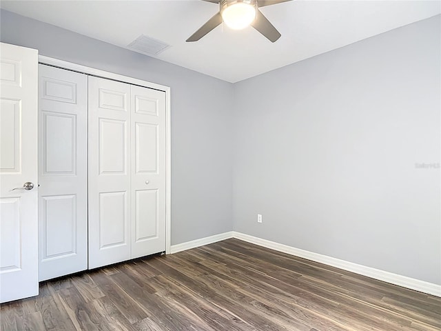 unfurnished bedroom with ceiling fan, visible vents, dark wood finished floors, baseboards, and a closet