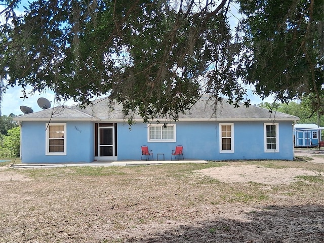 back of property with a patio area and stucco siding