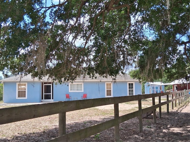 view of side of property with fence and stucco siding