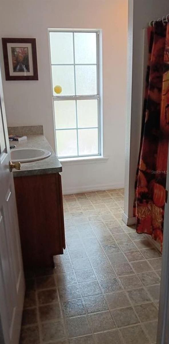 bathroom with curtained shower and vanity