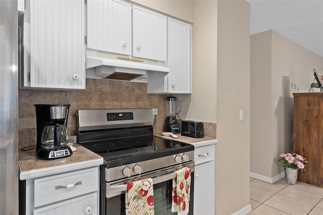 kitchen featuring light countertops, appliances with stainless steel finishes, under cabinet range hood, and tasteful backsplash