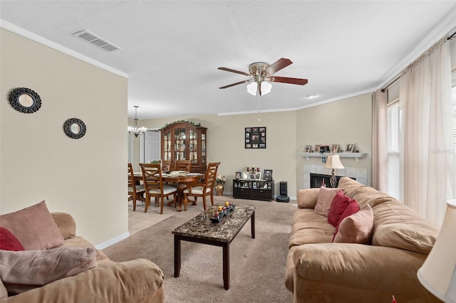 living room featuring visible vents, baseboards, ceiling fan with notable chandelier, ornamental molding, and carpet