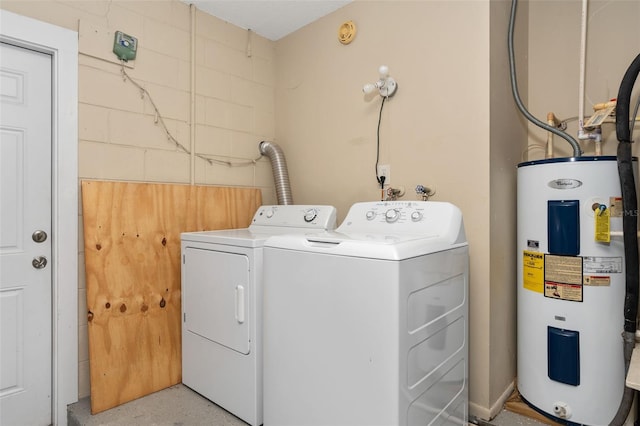 washroom featuring water heater, laundry area, and washer and dryer