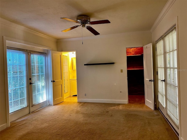 carpeted empty room featuring crown molding, ceiling fan, and a wealth of natural light