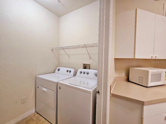 3577 Conroy Rd Unit 331, Orlando, FL 32839 - laundry room with separate washer and dryer, a textured wall, baseboards, and cabinet space