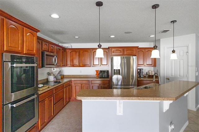 2806 Polson Dr, Kissimmee, FL 34758 - kitchen featuring appliances with stainless steel finishes, a sink, light tile patterned floors, an island with sink, and recessed lighting
