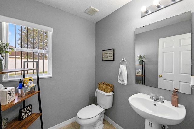 2806 Polson Dr, Kissimmee, FL 34758 - bathroom featuring a sink, plenty of natural light, toilet, and baseboards