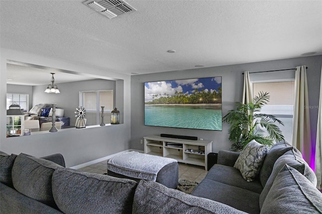 2806 Polson Dr, Kissimmee, FL 34758 - living room with tile patterned floors, a chandelier, baseboards, and a textured ceiling