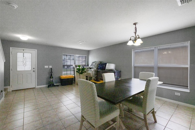 2806 Polson Dr, Kissimmee, FL 34758 - dining room with light tile patterned floors, a chandelier, healthy amount of natural light, baseboards, and a textured ceiling