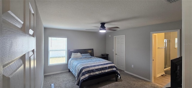 bedroom featuring baseboards, a textured ceiling, and carpet