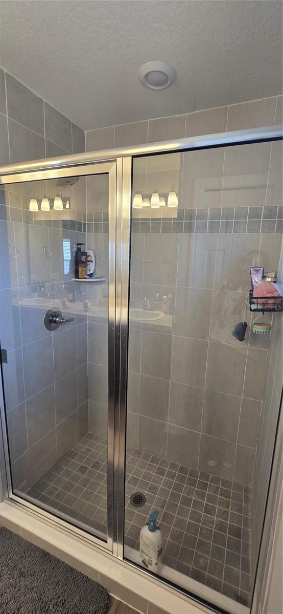 bathroom featuring a textured ceiling and a shower stall