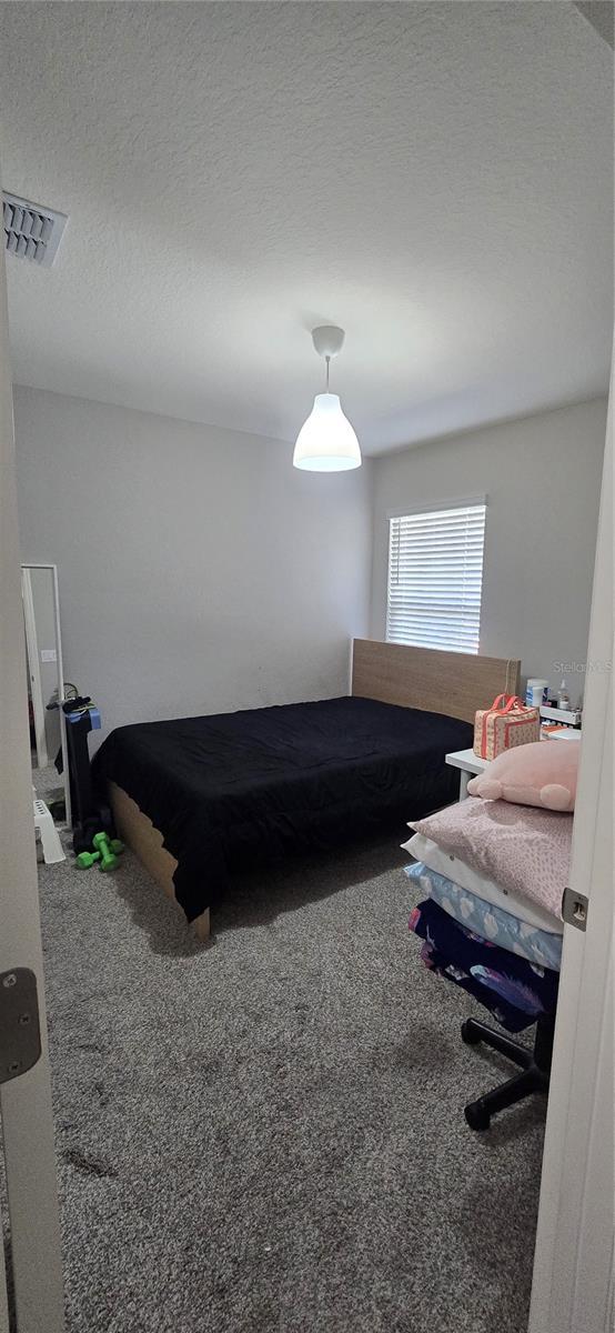 bedroom featuring visible vents and carpet