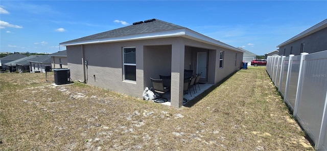 view of home's exterior featuring a patio, fence, central AC unit, and stucco siding