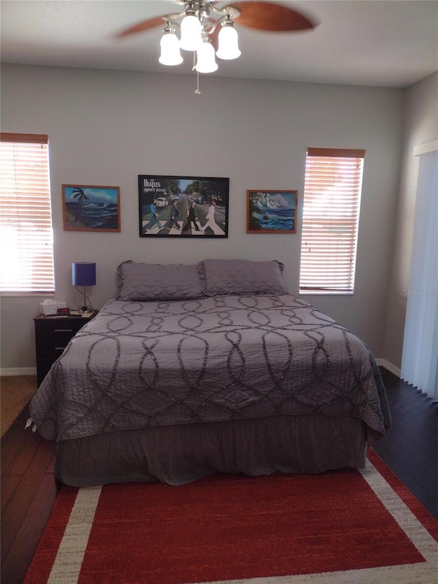 bedroom with a ceiling fan, baseboards, and wood finished floors