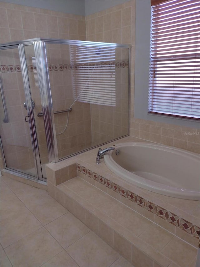 full bathroom featuring tile patterned floors, a bath, and a stall shower