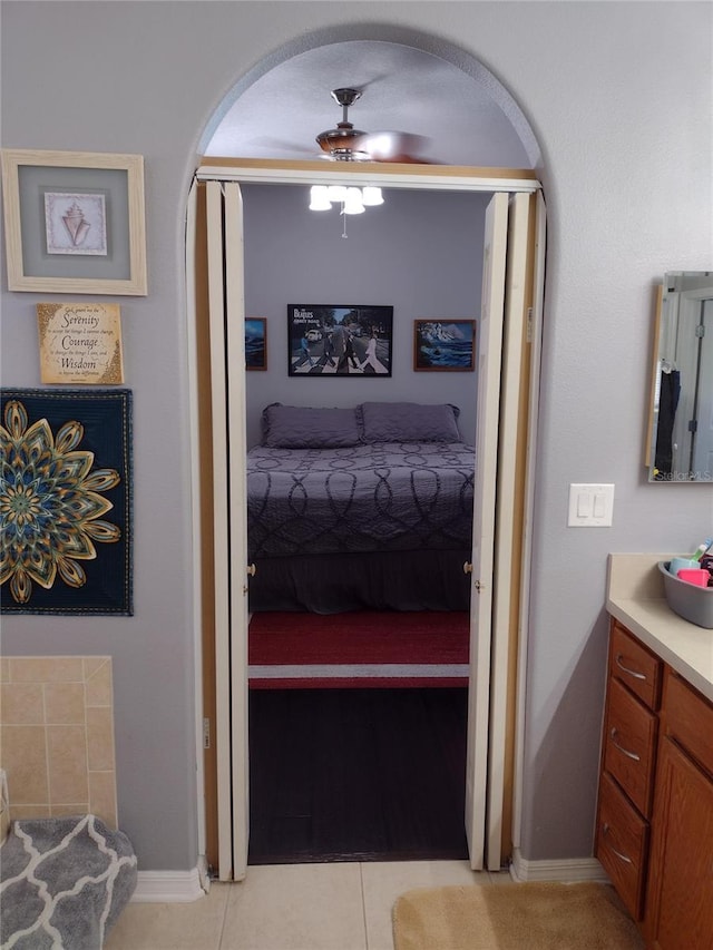 bathroom featuring ceiling fan, ensuite bath, vanity, tile patterned floors, and baseboards