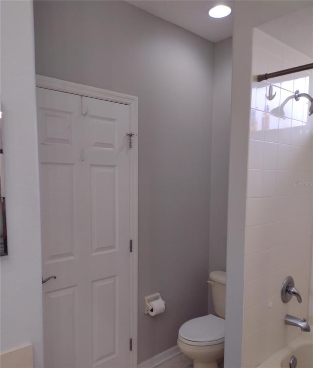 full bathroom featuring baseboards, tub / shower combination, and toilet