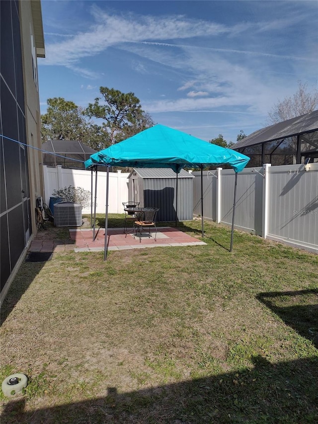 view of yard featuring a fenced backyard, a patio area, and central AC