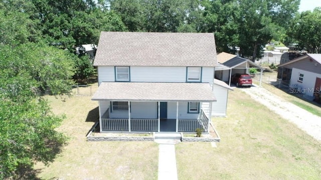 view of front of home with covered porch, a shingled roof, a carport, and a front lawn