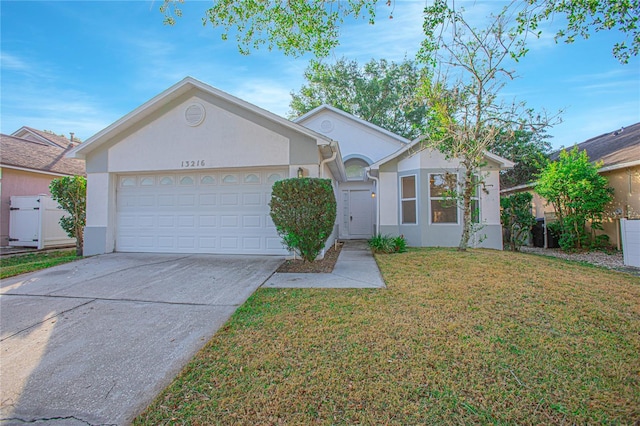 ranch-style house with concrete driveway, a garage, a front yard, and stucco siding